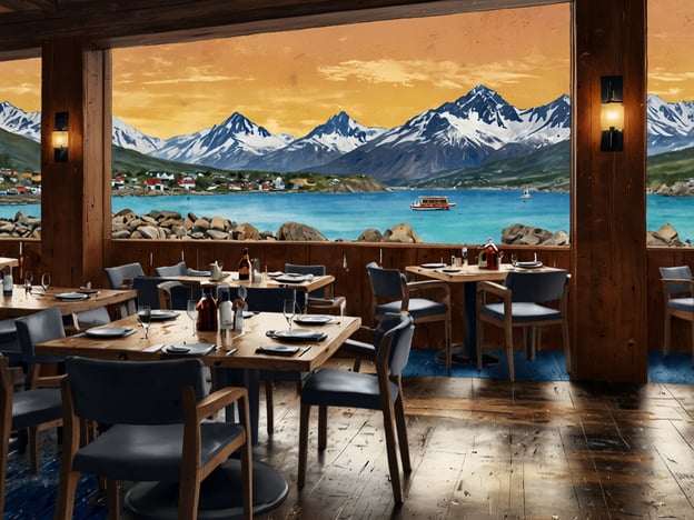 Auf dem Bild ist ein einladendes Restaurant in Ushuaia zu sehen, das eine atemberaubende Aussicht auf die umliegenden Berge und das Gewässer bietet. Die warmen Farben des Himmels bei Sonnenuntergang schaffen eine gemütliche Atmosphäre. Die Holzmöbel und der geschmackvolle Tischaufbau laden dazu ein, die kulinarischen Köstlichkeiten der Region zu genießen. Man kann sich gut vorstellen, dass hier lokale Spezialitäten serviert werden, während man den malerischen Ausblick genießt.